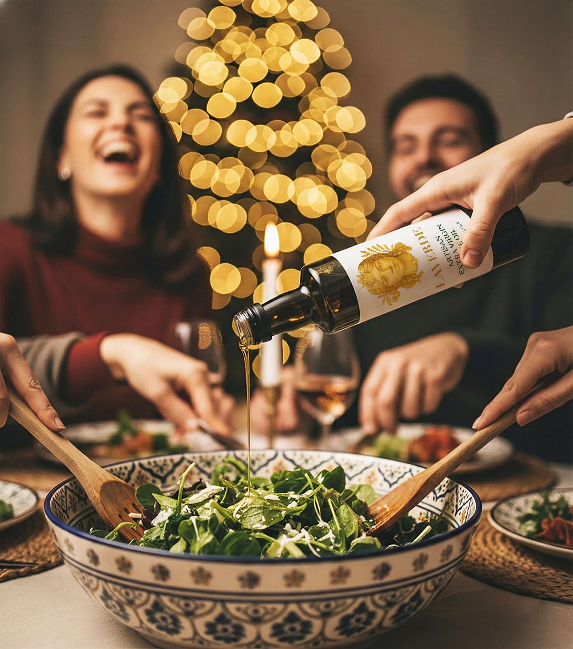 Sicilian Extra Virgin Olive Oil 500ml poured over a fresh salad — Laverde Artisan cold-pressed Sicilian EVOO with people smiling in the background, perfect for festive family meals.